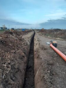 Полагане на гравитачен колектор PVC-U SN8 в дълъг извънградски изкоп.